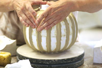 Sculpting a model for an urn mold.